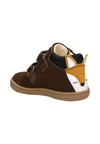 Braune Wildleder-Stiefeletten mit doppelten Klettverschluss-Riemen, ausgestattet mit einem weißen und braunen Fuchs-Gesichtdetail auf der Rückseite und einer Gummisohle.