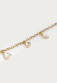 Gold chain bracelet with three clear gemstone charms in pear, round, and marquise shapes on a white background.