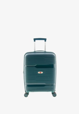 Maleta rígida de color verde azulado oscuro, con diseño texturizado de ondas, asa retráctil y ruedas giratorias para facilitar la movilidad.