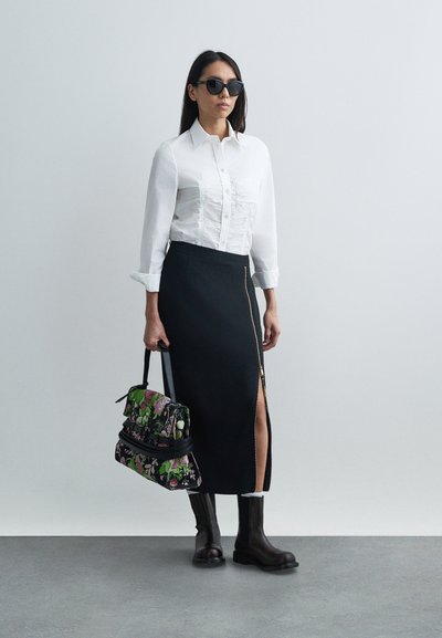 Cămașă albă cu nasturi și detalii texturate, fustă neagră cu fermoar și despicate, geantă cu model floral și bocanci negri până la gleznă.