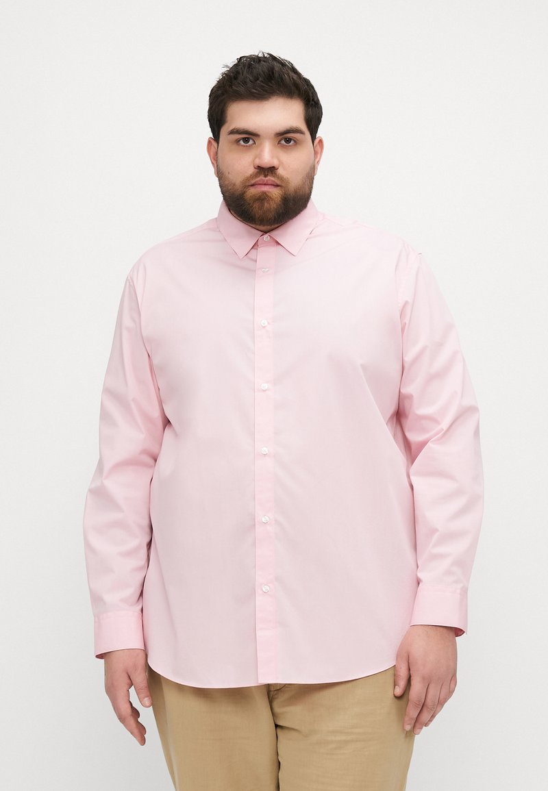 Camisa de botón de manga larga en rosa claro con cuello clásico y botones blancos, hecha de una tela suave. Ajuste estándar, diseño liso.