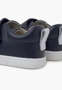 Navy blue leather sneakers with a white rubber sole and heel tab. Features smooth texture and minimalistic design.