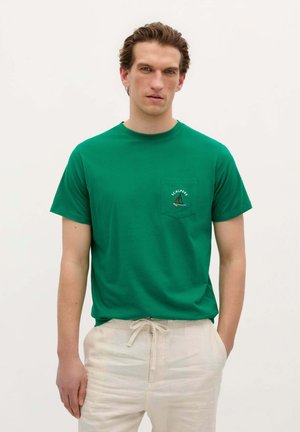 Grünes Baumwoll-T-Shirt mit Rundhalsausschnitt und kurzen Ärmeln, das eine Brusttasche mit gesticktem Boot-Design aufweist.