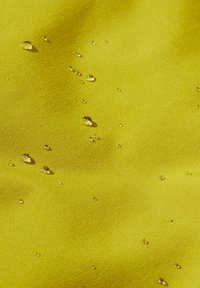 Wasserabweisender gelber Stoff mit glatter Textur, auf dessen Oberfläche Wassertropfen zu sehen sind, die seine hydrophoben Eigenschaften demonstrieren.