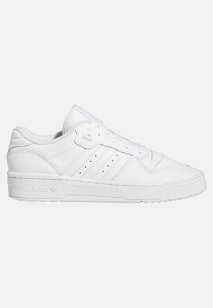 Baskets basses blanches Adidas avec lacets à l’avant, trois bandes sur le côté et semelle texturée sur fond uni.