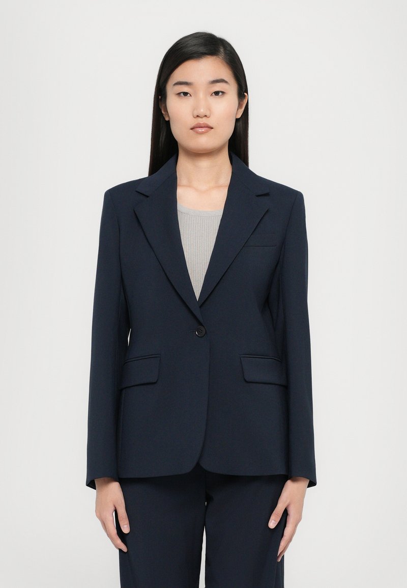 Blazer navy con chiusura a un bottone, revers a punta e due tasche frontali, realizzato in un tessuto liscio e di texture uniforme.
