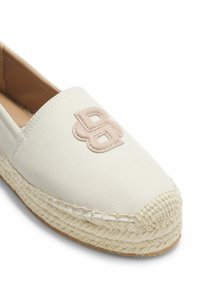 Chaussure espadrille en toile crème avec semelle en jute tressée et logo "BB" beige entrelacé cousu sur la partie supérieure avant.
