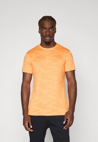 Kortærmet orange t-shirt lavet af et glat, let stof med et subtilt camo-mønster og en klassisk rund halsudskæring.