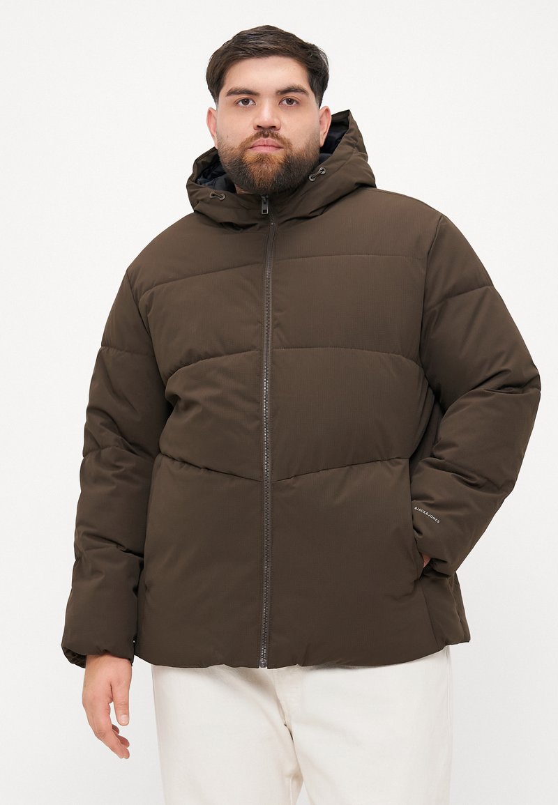 Giacca puffer marrone con cappuccio, caratterizzata da una chiusura con zip, design trapuntato e tasche laterali. Texture liscia con una vestibilità comoda.