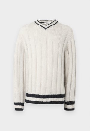 White knitted sweater with vertical ribbing, V-neckline, and black striped accents on the collar, cuffs, and hem. Soft texture.