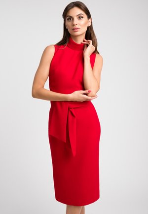 Czerwona sukienka bez rękawów z wysokim kołnierzem, paskiem w talii oraz dopasowanym krojem, wykonana z gładkiego materiału, do kolan, o minimalistycznym wzornictwie.