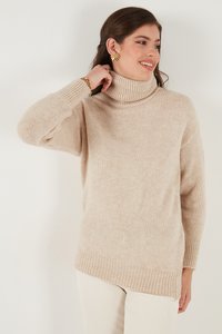 Pulover bej cu guler înalt dintr-un material moale. Prezintă manșete și tiv cu nervuri, având o croială lejeră și slituri pe lateral pentru un plus de confort.