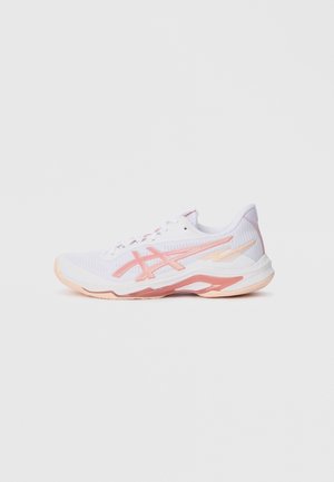 Zapatilla deportiva blanca y rosa con parte superior de malla, cierre de cordones y suela texturizada, posicionada de lado sobre un fondo liso.