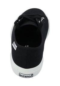 Black canvas sneaker with white rubber sole. Features round toe, black laces, and a logo tag on the side. Classic, minimalist design.