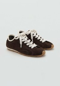 Zapatillas de ante marrón con cordones blancos, suelas de goma y diseño de puntera redondeada. Presentan acentos contrastantes y una forma de perfil bajo.
