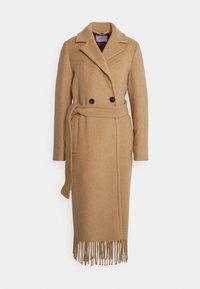 Manteau long en laine couleur camel avec de larges revers, double boutonnage noir, taille ceinturée et ourlet à franges.