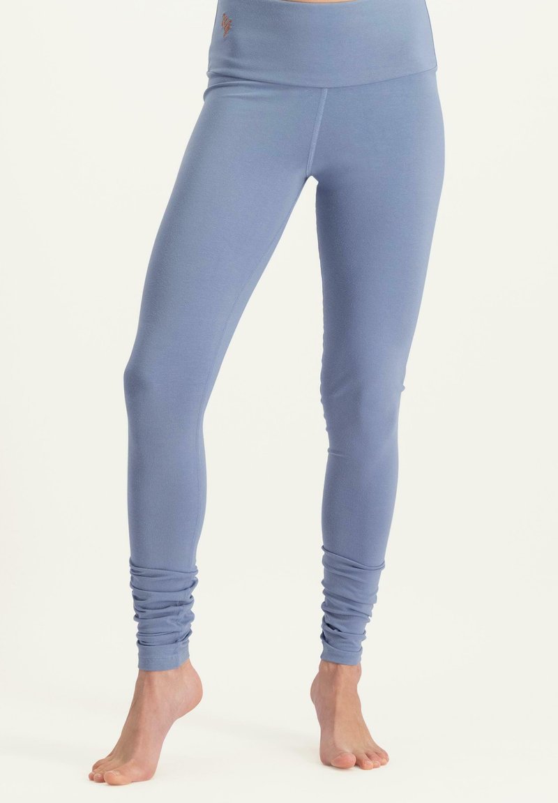 Siniset leggingsit, jotka on valmistettu pehmeästä ja joustavasta materiaalista. Korkea vyötärö ja sileä pinta. Kerääntyvä yksityiskohta nilkoissa.