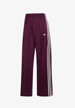 Pantaloni da corsa Adidas color marrone con vita elastica, tre strisce bianche laterali, tasca con zip e logo ricamato sulla coscia sinistra.