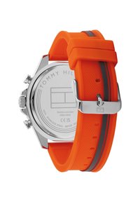 Tommy Hilfiger Uhr mit einem orangefarbenen Silikonarmband, Gehäuse aus silbernem Edelstahl, strukturierten Oberflächen und einem grauen Akzentstreifen.