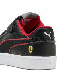 Mustikkamusta nahkakerros lenkkari punaisilla yksityiskohdilla ja valkoisella pohjalla. Varustettu Ferrari-logolla ja Puma-brändäyksellä kantapäässä. Kuviollinen design.
