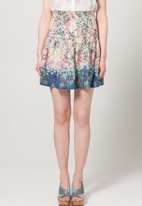 Falda con estampado floral en tonos pastel, con pliegues y un degradado de rosa a azul. Fabricada con un tejido ligero, de longitud por encima de la rodilla.