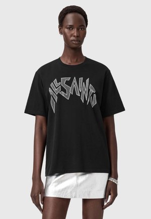 Zwarte katoenen T-shirt met vet zilverkleurig logo "ALLSAINTS" in een hoekig lettertype. Korte mouwen, ronde halslijn, gecombineerd met een metallic zilveren rok.