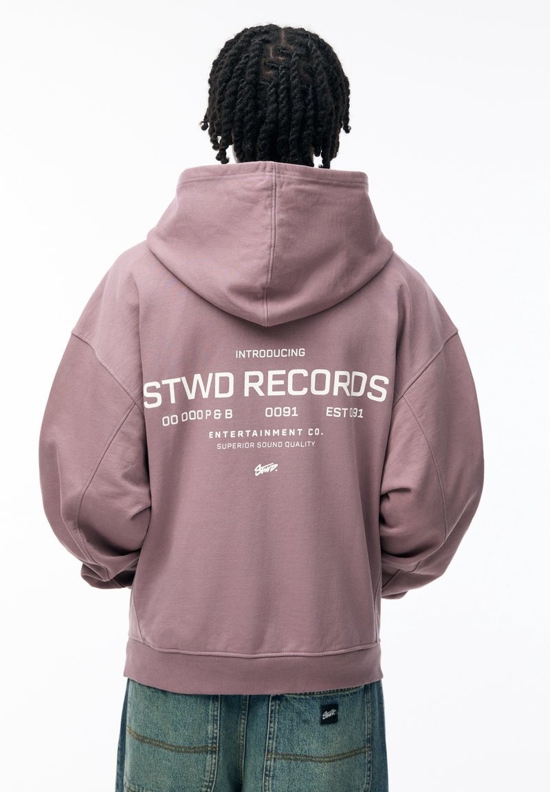 Lila übergroße Kapuzenpullover mit weißem Text auf der Rückseite, der "STWD RECORDS" sagt, aus weichem Stoff gefertigt und mit Kapuze.