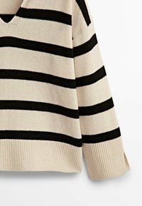 Beige gebreide trui met zwarte horizontale strepen, V-hals, doorgezakte schouders en geribbelde zoom. Heeft zijslits voor bewegingsgemak.