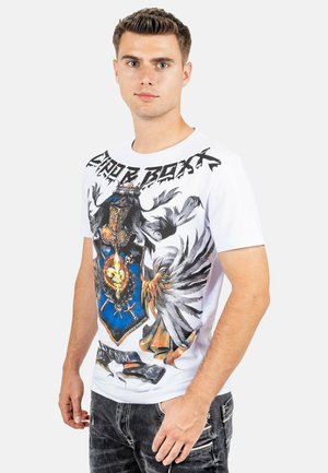 T-shirt bianco a maniche corte con un design grafico colorato di un'aquila araldica e uno scudo con il testo "DENIM" in basso.