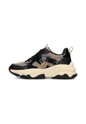 Chaussure de sport noire et beige avec une tige en mesh, des accents brillants, une semelle texturée et un design épais avec une languette au talon.