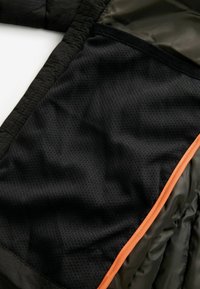 Tessuto a rete nera con un bordo arancione, mostrato accanto a un materiale verde oliva testurizzato, con un design a tasca.
