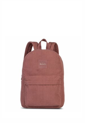 Staubrosafarbener Cordrucksack mit Frontreißverschlusstasche und gepolsterten Schulterriemen, mit mittig angebrachtem Bench-Markenlabel.