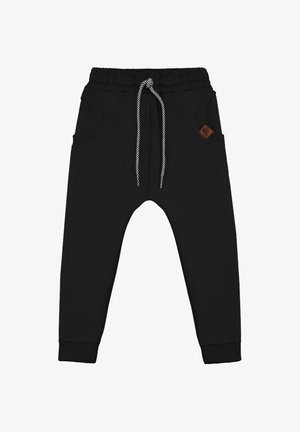 Czarne spodnie dresowe z elastycznym pasem, sznurkiem w paski, ściągaczami na nogawkach oraz dwoma okrągłymi przednimi kieszeniami, z których jedna ma małą brązową naszywkę z logo.