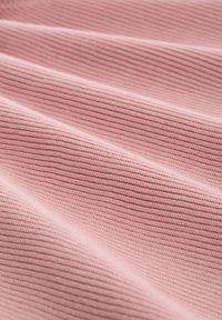 Close-up van zacht roze ribbelstof met diagonale plooien en fijne horizontale brei-textuur.
