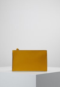 Pochette gialla in pelle con forma rettangolare, texture liscia e chiusura con zip. Design minimalista con un accento argento a contrasto.