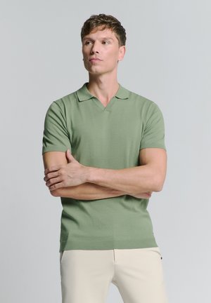Polo à manches courtes en coton mélangé vert doux. Dispose d'un col et de poignets côtelés, avec une coupe ajustée et une texture lisse.