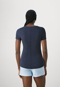 Navy blue short-sleeve t-shirt with a slim fit, smooth texture, and rounded neckline, paired with light blue striped shorts.