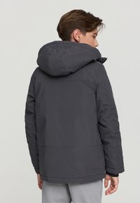 Szara kurtka puchowa z kapturem, o gładkiej fakturze i luźnym kroju, widoczna z tyłu, o prostym designie i bez zauważalnych akcentów.