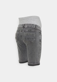 Grå denimshorts med uppvikta fållar, elastisk grå midja och två bakfickor med sömnadsdetaljer. Slät textur och figurnära design.