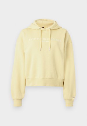 Sudadera corta de color amarillo claro con cordones, puños y dobladillo acanalados, y texto blanco "Tommy Hilfiger EST. 1985" en el pecho.