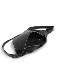 Borsa a tracolla nera in pelle con scomparto principale con zip, tracolla regolabile e superficie morbida e texture.