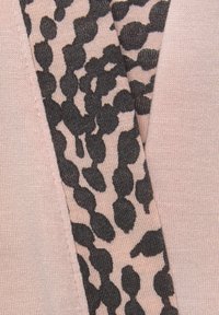 Rosa Stoff mit glatter Textur, der ein schwarzes Tiermuster in unterschiedlichen Größen aufweist und einen Kontrast zum einfarbigen Hintergrund bildet.