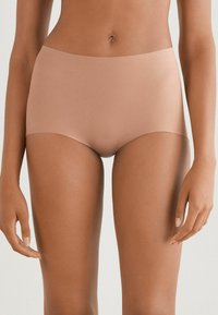 Beige hladké vysoké kalhotky s bezšvým designem. Mají široký pas a minimalistický styl, který poskytuje plné pokrytí.