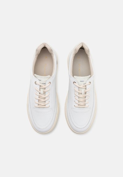 Weiße Ledersneaker mit beigen Schnürsenkeln und einer cremefarbenen Sohle. Runde Zehenform, dezente Nähdetails und weiche Innenauskleidung. Minimalistisches Design.