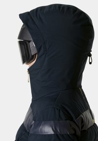 Navyblaue, isolierte Jacke mit großer Kapuze, glänzenden schwarzen Akzenten, gestepptem Muster und einer seitlichen Reißverschlusstasche für zusätzlichen Nutzen.
