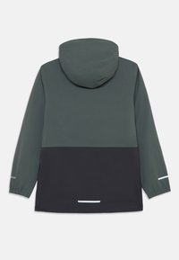 Veste imperméable avec capuche, design bicolore en vert foncé et noir, poignets élastiques et accents réfléchissants.
