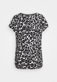 Bluzka z krótkim rękawem z czarno-białym wzorem w panterkę, okrągłym dekoltem i lekko zaokrąglonym dołem oraz luźnym krojem.