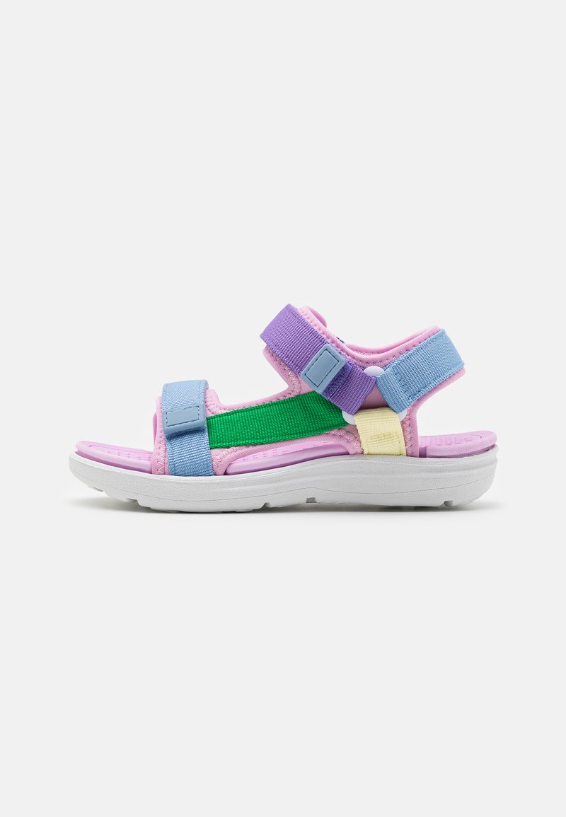 Colorful sandal with a white sole, featuring blue, pink, purple straps, and a green accent. Made of textured fabric with adjustable closures.