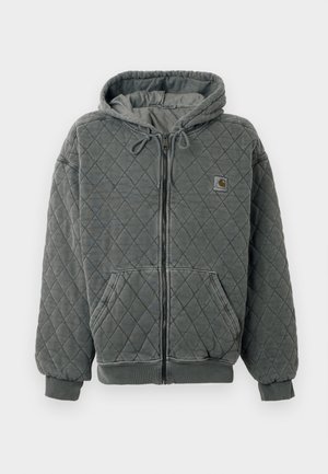Siva prešita kapucar z zadrgo na sprednji strani, s kapuco na vrvico in velikimi žepi. Ima rebraste manšete in rob, ter majhno nalepko z logotipom na prsih.