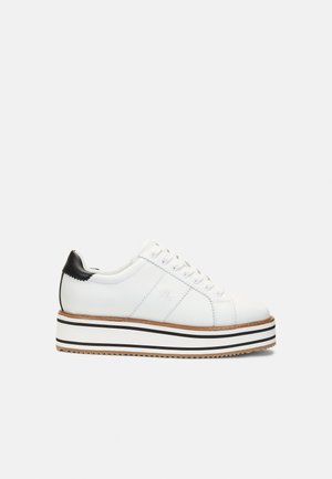 White leather sneaker with a black heel cap and textured white sole. Features a contrasting striped platform and six eyelets with laces.